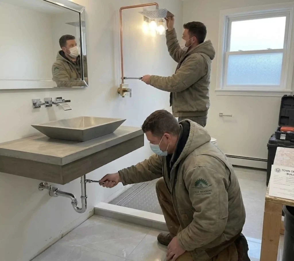 Contractor installing modern bathroom vanity and fixtures in Westborough